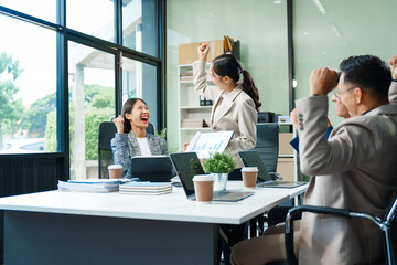 In a boardroom, an Asian team meets at a desk, presenting financial terms and strategies....