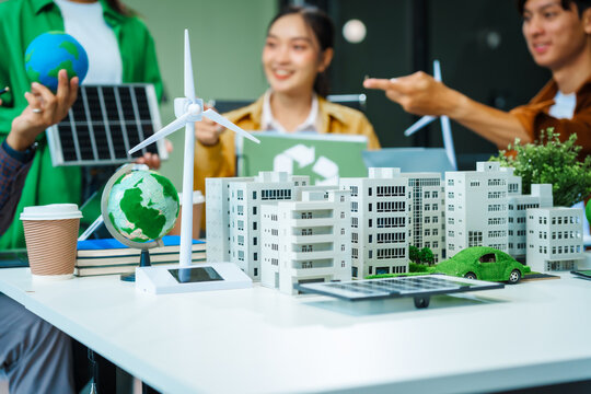 Colleagues in formal suits meet at desk to brainstorm environmental management strategies. discuss carbon emissions, renewable energy, sustainable business practices to reduce corporate footprint. - Powered by Adobe