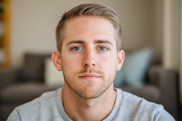 Fototapeta premium A close-up portrait of a young white man wearing a casual t-shirt, with a blurred background.