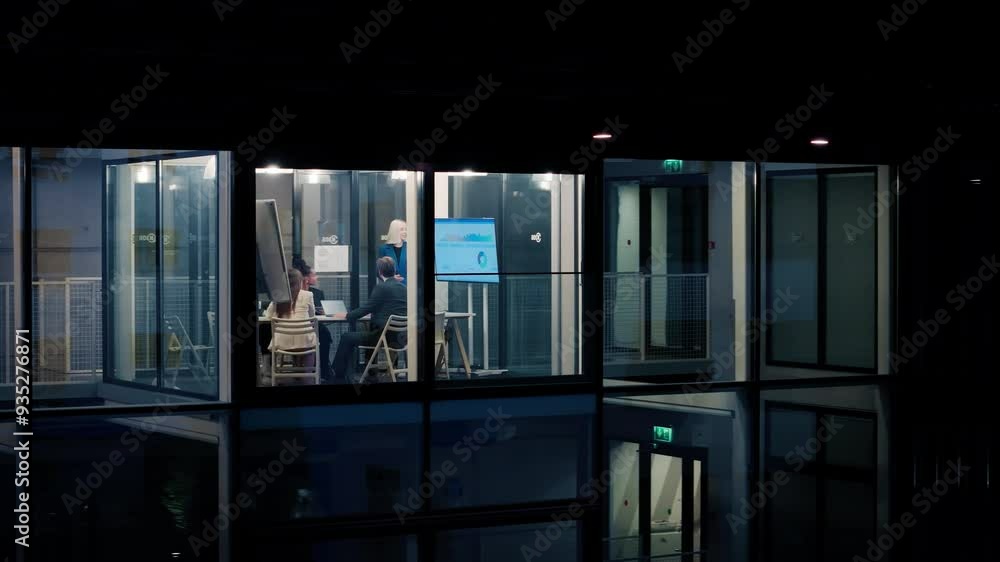 Poster female manager making a presentation to a board of directors in a meeting room late in the evening. 