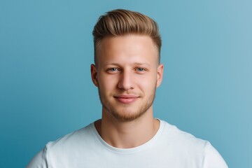 Fototapeta premium A studio close-up portrait of a young white man wearing a casual t-shirt, with a colourful background.