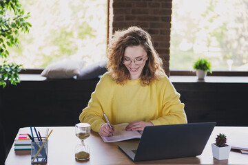 Photo of nice young woman write notebook elearning netbook dressed yellow sweater comfortable light...