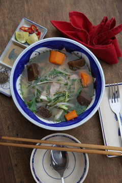 Phở or Pho is a Vietnamese soup. Phở b&ograve;, pho bo - traditional national soup, dish, cuisine. Tasty food in Vietnam. Plate with Vietnamese yammy hot phở, spisy pho bo