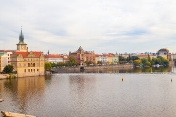 Obraz premium A scenic view of the riverside in Prague. Historic buildings along the water.