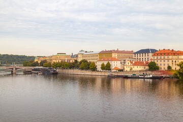 View of Jiraskuv Most and Vltava River. Panorama of embankment with historical buildings. Prague, Czech Republic.