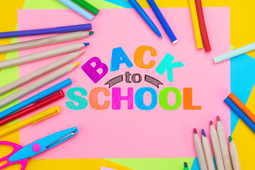 Back to school background. Top view flat lay concept. Childish lettering, colored paper, supplies, stationery for primary school, elementary school or grade school, preschool educational