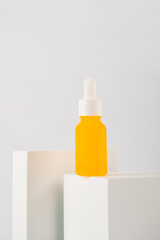 Yellow glass cosmetic bottle, Skin care or sunscreen cosmetic with stylish props on white...