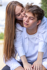 Fototapeta premium Close-up portrait of couple in love. Young woman and men walking and having fun in park on warm summer day. Vertical photo. High quality photo