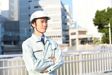 作業服姿のヘルメットをつけたアジア人男性