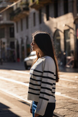 Fototapeta premium Portrait of a girl in a sunrise golden hour morning in Milan, Italy, Europe