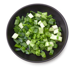 green onion in black bowl isolated on white background. clipping path. top view