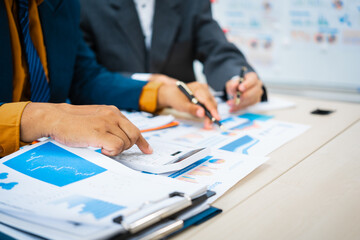 close-up of two professionals' hands meeting at a desk, discussing business strategies over a digital tablet and laptop. teamwork, planning, and communication in a corporate office setting.
