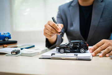 close-up of a customer signing a car insurance contract at an agency. The salesman hands over the keys, finalizing the agreement. importance of financial protection and assurance.