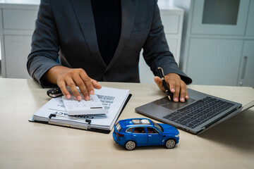 close-up of a customer signing a car insurance contract at an agency. The salesman hands over the...