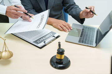 Thai lawyer in a suit works on a laptop at his office desk, with a gavel beside him. intersection of technology and law, representing professionalism, legal expertise, and corporate business.