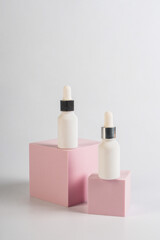 White glass cosmetic bottle in hand, Skin care or sunscreen cosmetic with stylish props on white background.