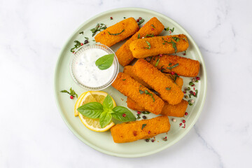 Fish and chips .Close up of crispy breaded deep fried fish fingers with breadcrumbs served with...