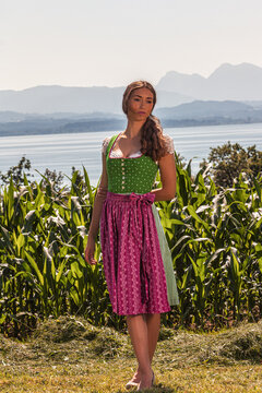 "Traditionelle Sch&ouml;nheit: Frau im Dirndl vor Berg- und Seelandschaft"