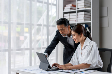 A man and a woman are working together on a laptop
