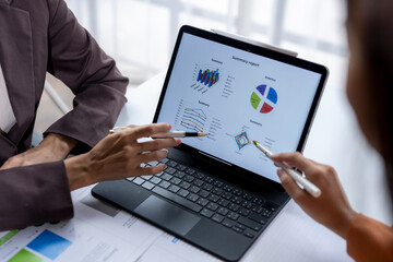 Businesswomen analyzing financial data on tablet using stylus pens