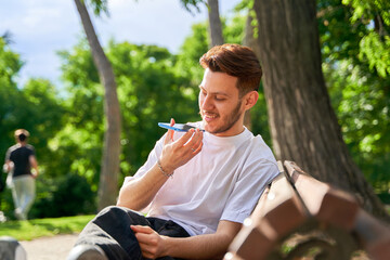 Man dictating audio message on smart phone in a park