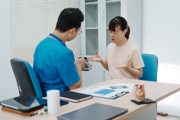Obraz premium Asian female doctor listens to belly of pregnant mother during a prenatal exam in clinic. doctor provides caring advice, ensuring the health and happiness of the expecting mother and baby.