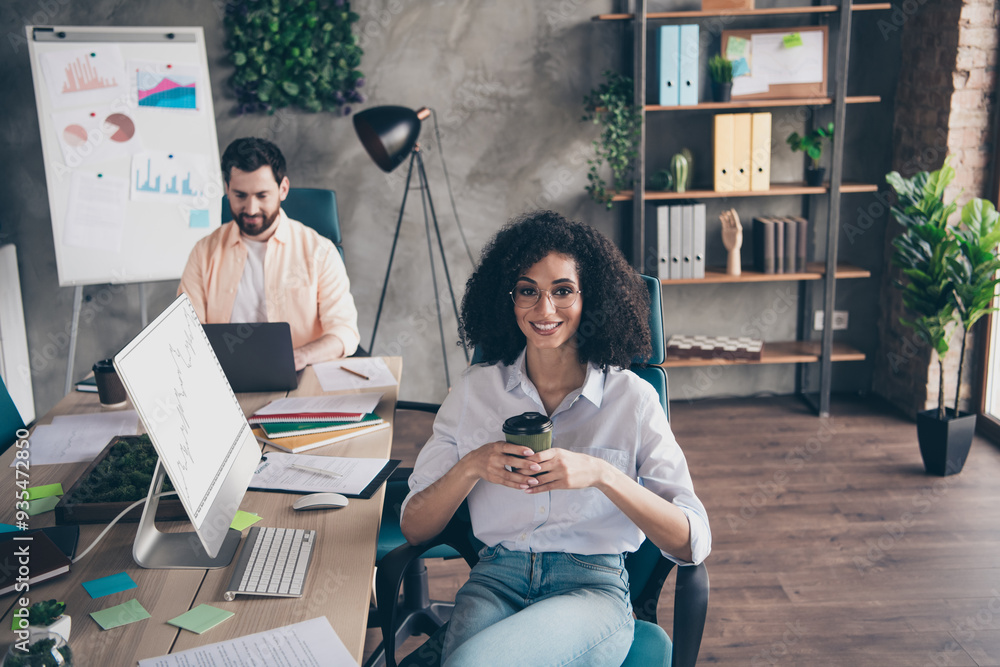 Poster Photo of two young colleagues drink coffee use computer loft interior office business center indoors