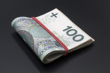 Pieniądze, Polskie złotówki, banknoty spięte gumką.