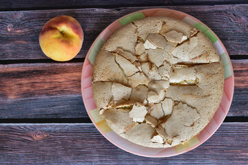 Fresh baked homemade charlotte pie with peaches. Cake with crispy crust served on rustic wooden table. Juicy peach fruit. Top view.