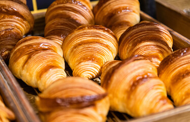 Trays of freshly baked croissants in a bakery. Bread making business