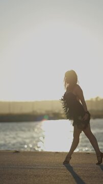 Woman performing latin dance routine at sunset