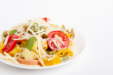 Pasta, macaroni with tomatoes and cheese in a plate on a light background.