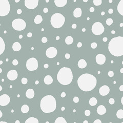 Snow seamless pattern. Hand drawn dots. White spots on pastel green background. Big and small blobs.