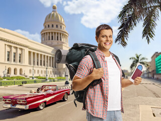 Male tourist with a backpack holding a passport in Havana