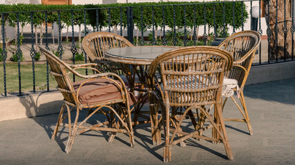 wooden rotan chairs and a round table on the background of the resort house in Egypt Dahab South Sinai