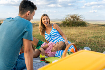 Obraz premium A daughter lies on her mother's lap and tells her parents about her day, father and mother listen carefully to their daughter's problems and adventures