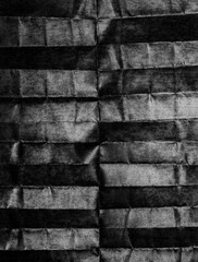 Black and white vintage background with a textured paper surface resembling folded striped cloth, in a monochrome, dark, hyper-realistic style.