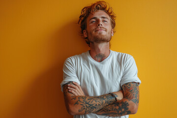 Obraz premium Tattooed man posing confidently against a vibrant yellow background