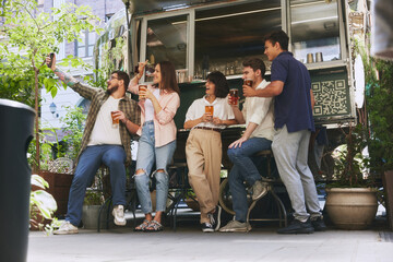 Happy smiling people, friends, men and women meeting at local outdoor bar, drinking beer and taking selfie with mobile phone. Cozy memories. Concept of relaxation, party, beer, festival, celebration