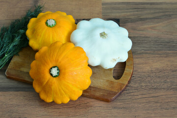 yellow and white pattypan squashes on cutting board top view  