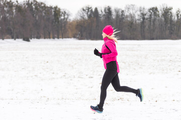 A Nice Young Woman Running in Snowy Park