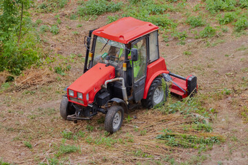 The grass mower on the tractor efficiently removes grass from the field.