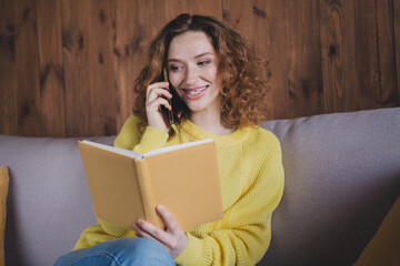 Photo of lovely young lady talk phone notebook dressed yellow sweater spend pastime spacious house...