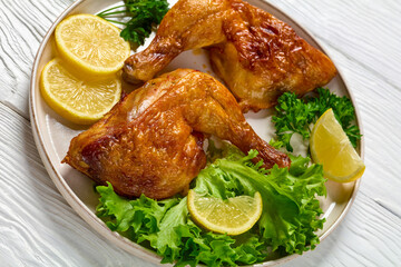 fried chicken legs with lettuce, lemon on plate