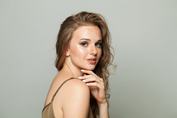 Fototapeta premium Perfect female face. Woman with makeup, curly hairstyle and fresh skin on white background