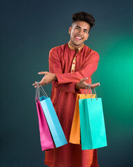 Indian traditional Young handsome man holding and posing with shopping bags on a dark background