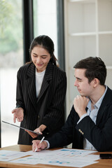 A woman and a man are sitting at a table with papers in front of them