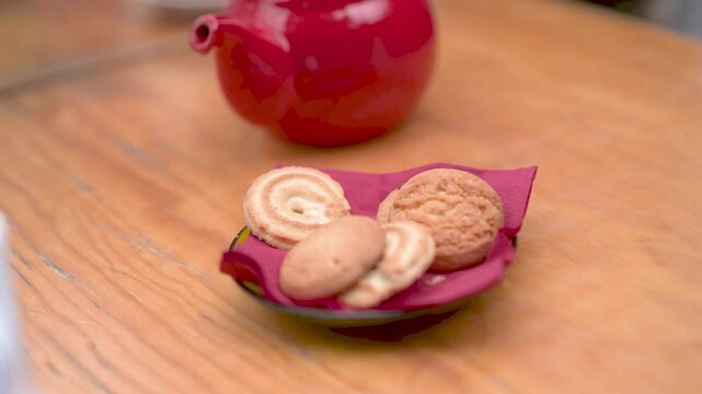 Woman picking danish butter cookies from plate in slow motion