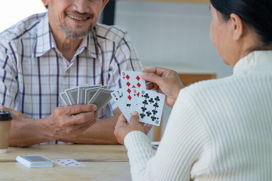 happy asian senior couple enjoy playing cards game together, concept elderly pensioner lifestyle, entertainment, recreation, encourages social interaction, help memory retention