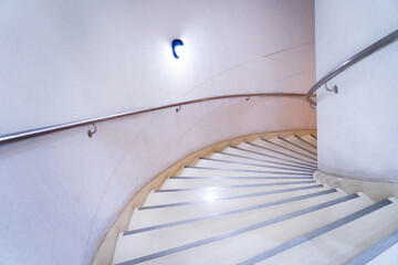 Large spiral staircase, staircase up and down, marble staircase in a modern building, natural light